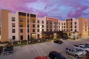 韦科Hilton Garden Inn Waco的停车场停着汽车的酒店