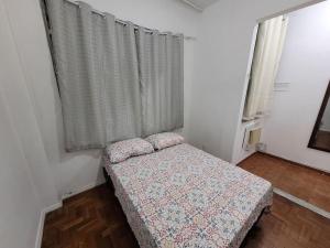 Habitación pequeña con cama y ventana en Suhcasa Cozy Praia Botafogo, en Río de Janeiro