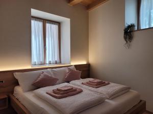 a bedroom with a bed with towels on it at Magnolia Levico in Levico Terme