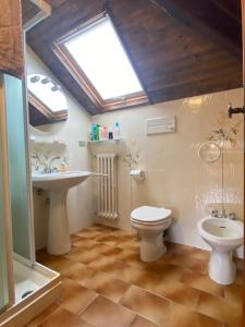 a bathroom with a toilet and a sink and a window at Casa Ribot: Alassio centro e mare a portata di mano in Alassio