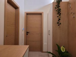un corridoio con porta in legno in una casa di Magnolia Levico a Levico Terme