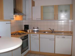 リンダウにあるFerienwohnung Damkrögerの白いキャビネットとシンク付きのキッチン