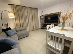 a living room with a couch and a table and a tv at Apartaments L’ARC in Palafrugell