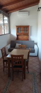 ein Wohnzimmer mit einem Tisch und einem Sofa in der Unterkunft villino 4 posti letto con cucina a 30mt dal mare in Fiumicino