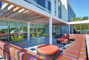 En un edificio hay un patio con mesas y sillas coloridas. en Home2 Suites By Hilton Richmond Hill Savannah I-95 en Richmond Hill