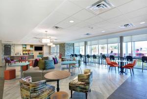 un vestíbulo con mesas y sillas y una cafetería en Home2 Suites By Hilton Richmond Hill Savannah I-95 en Richmond Hill