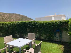 una mesa y sillas en un patio con un seto en Villa Karim en Nabeul