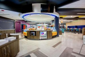 a fast food restaurant with a bar and tables and chairs at Tru by Hilton Lafayette River Ranch in Lafayette