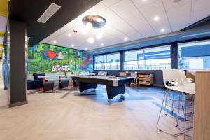 an office with a ping pong table and a large mural at Tru by Hilton Lafayette River Ranch in Lafayette