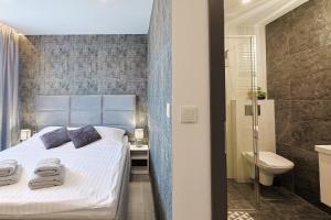 a bedroom with a bed and a bathroom with a shower at AURORA JAROSŁAWIEC in Jarosławiec +85 photos