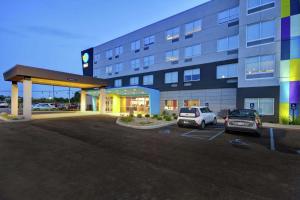 a large building with cars parked in a parking lot at Tru By Hilton Fort Wayne in Fort Wayne