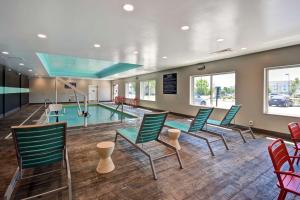 a pool room with chairs and a swimming pool at Tru By Hilton Fort Wayne in Fort Wayne