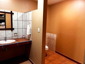 ein Bad mit einem Waschbecken und einem WC in der Unterkunft Belen Suites in San Antonio