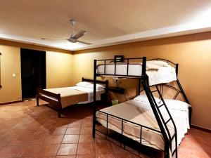 a room with three bunk beds and a ceiling at Belen Suites in San Antonio