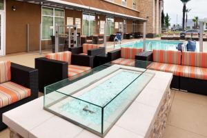 a swimming pool with a table and chairs and a swimming pool at Hampton Inn & Suites Buena Park in Buena Park