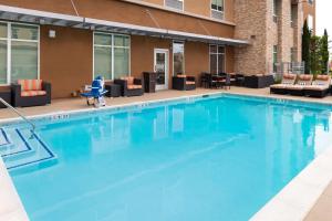 a large blue swimming pool with chairs and tables at Hampton Inn & Suites Buena Park in Buena Park
