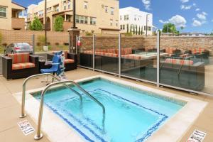 a swimming pool with a patio with a couch and chairs at Hampton Inn & Suites Buena Park in Buena Park