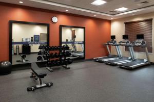 a gym with several tread machines and mirrors at Hampton Inn & Suites Buena Park in Buena Park