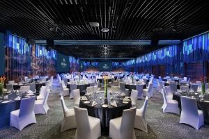 un salón de banquetes con mesas y sillas blancas en Hilton Port Moresby Hotel & Residences en Port Moresby