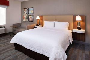 a hotel room with a large bed and a couch at Hampton Inn & Suites Buena Park in Buena Park
