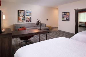 a hotel room with a desk and a couch at Hampton Inn & Suites Buena Park in Buena Park
