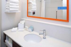 a bathroom with a sink and a mirror and towels at Hampton Inn & Suites Buena Park in Buena Park