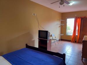 a bedroom with a bed and a tv and a window at Belen Suites in San Antonio