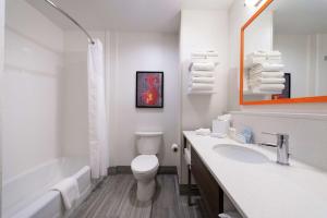 a white bathroom with a toilet and a sink at Hampton Inn & Suites Buena Park in Buena Park