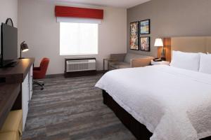 a hotel room with a bed and a television at Hampton Inn & Suites Buena Park in Buena Park