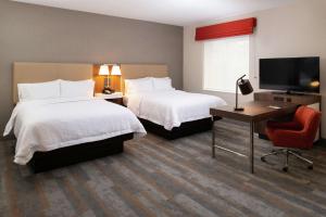 a hotel room with two beds and a flat screen tv at Hampton Inn & Suites Buena Park in Buena Park