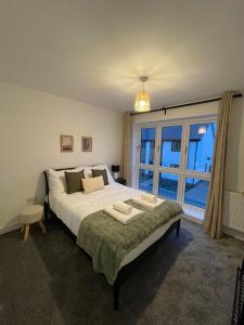 a bedroom with a large bed and a large window at The Cowshed, SAV - Romney Sands Beach House in Littlestone-on-Sea