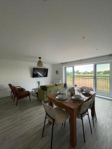 a living room with a table and a couch at The Cowshed, SAV - Romney Sands Beach House in Littlestone-on-Sea