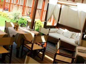 a porch with a couch and a table and chairs at Hotel La Pigna in Marina di Pietrasanta