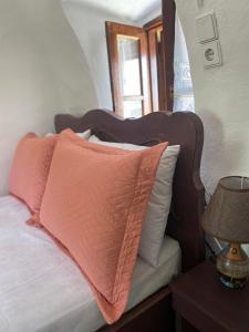 a bed with a wooden head board with pillows on it at Terra Petra Mani in Koíta