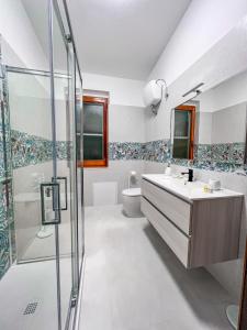y baño con lavabo y ducha. en Villa Gladyr, en Lotzorai