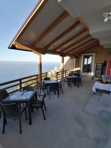 un patio con tavoli, sedie e vista sull'oceano di San Giacomo Relais a Furore