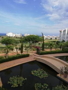 une piscine d'eau avec des nénuphars dans un parc dans l'établissement Asilah marina golf, à Assilah