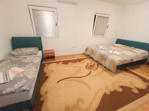 een slaapkamer met 2 bedden en een groot tapijt bij Jablanica villa with pool in Jablanica