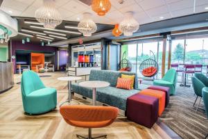 una sala de espera con mesas y sillas coloridas en Tru By Hilton Bowling Green en Bowling Green