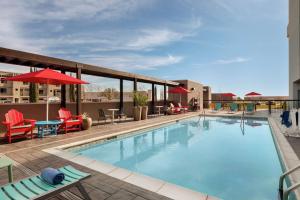 uma piscina com cadeiras e guarda-sóis num hotel em Home2 Suites By Hilton San Antonio North Stone Oak em San Antonio