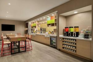 a restaurant with a table and a kitchen with a counter at Home2 Suites By Hilton San Antonio North Stone Oak in San Antonio