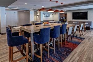 une salle à manger avec une grande table et des chaises bleues dans l'établissement Hampton Inn Discovery Kingdom Napa Gateway, à Vallejo