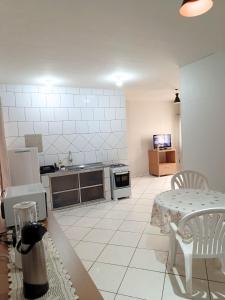 a kitchen with a table and a table and a kitchen with a table at Lindo Apto103 em Primavera do Leste in Primavera do Leste +6 photos