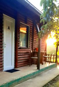 uma cabana de madeira com uma porta e uma janela em Sunny Side Fruska Gora- Studio A em Velika Remeta