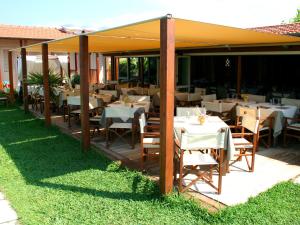 a restaurant with tables and chairs under a pavilion at Hotel La Pigna in Marina di Pietrasanta