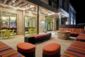 a restaurant with benches and a table and chairs at Home 2 Suites By Hilton Dothan in Dothan