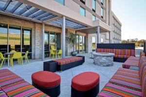 多森Home 2 Suites By Hilton Dothan的庭院配有色彩缤纷的家具和桌椅。