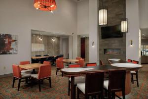 a restaurant with tables and chairs and a fireplace at Homewood Suites By Hilton Cincinnati Midtown in Cincinnati