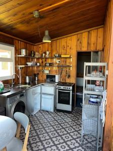 a kitchen with wooden walls and a stove top oven at Madame Chalet in Seaton