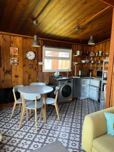 a kitchen with a table and chairs in a room at Madame Chalet in Seaton